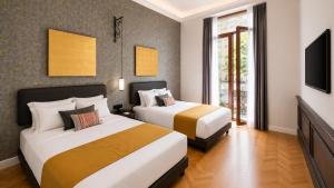 a hotel room with two beds and a television at Hotel Bellas Artes in Mexico City +64 photos