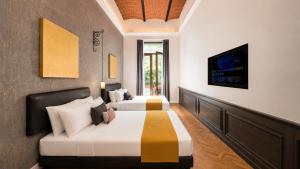 a hotel room with two beds and a tv at Hotel Bellas Artes in Mexico City