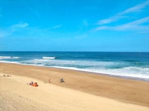 a group of people on a beach near the ocean at Labenne beach apartment in Labenne