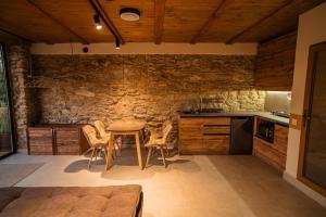 a kitchen with a table and chairs and a stone wall at Terra House in Andrushovka +6 photos