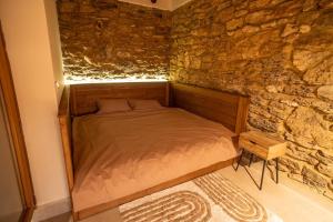 a bed in a room with a stone wall at Terra House in Andrushovka
