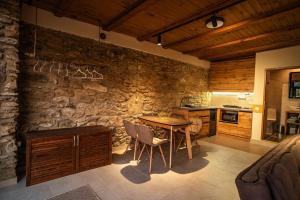a kitchen with a table and a stone wall at Terra House in Andrushovka