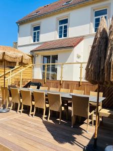 a dining table and chairs on a wooden deck at Villa Le Cygne in Wimereux
