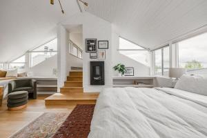 a white bedroom with a large bed and a staircase at Crows Nest Condo 3BR Downtown in Anchorage +36 photos