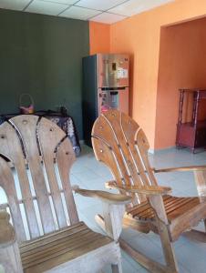 two wooden chairs and a table and a refrigerator at Casa de Malle in Pocrí