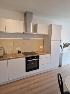 a kitchen with white cabinets and a black oven at Studio Kortrijk in Kortrijk