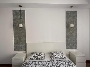 a bedroom with a bed and two night stands at Green Deluxe Apartment Cosmopolis in Ştefăneştii de Jos