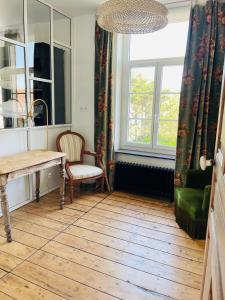 a room with a table and a chair and a window at Villa Le Cygne in Wimereux