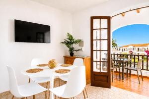 a white dining room with a white table and white chairs at Turquoise Menorca By the Sea in Son Bou