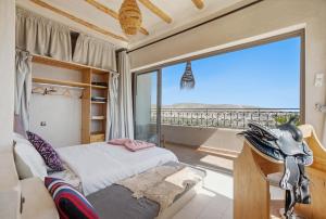 a bedroom with a bed and a large window at Surf Appart Morocco in Tamraght Ouzdar