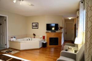 a living room with a bath tub and a tv at Motel Bel-Eau in Montebello
