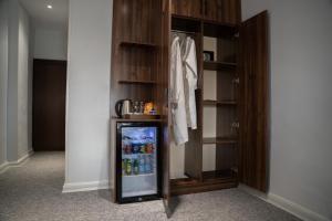 a small refrigerator in a room with shelves at Burj Al Salam Hotel in Al ‘Alwīyah +10 photos