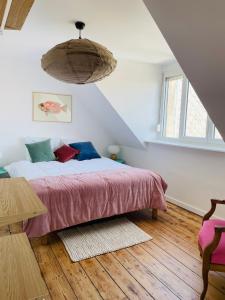 a bedroom with a bed with a pink blanket at Villa Le Cygne in Wimereux