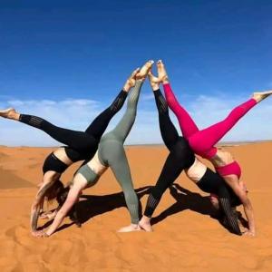 a group of women doing yoga on the beach at marvelous luxury desert stars in Merzouga