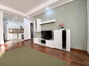 a large living room with white cabinets and a television at Green Deluxe Apartment Cosmopolis in Ştefăneştii de Jos