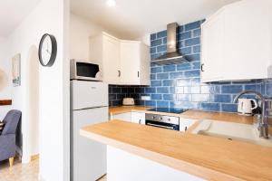 a kitchen with white appliances and blue tiles at Turquoise Menorca By the Sea in Son Bou +24 photos