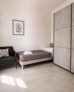 a small bedroom with a bed and a chair at Life Vesuvio in Torre del Greco