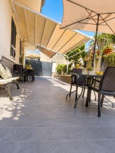 a patio with tables and chairs and an umbrella at Life Vesuvio in Torre del Greco