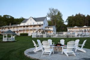 a group of white chairs and a table in front of a large house at The Water Street Inn in Ephraim