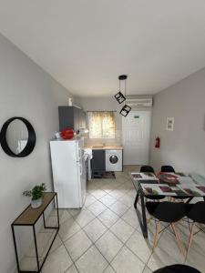 a kitchen with a white refrigerator and a table and chairs at Modern home in Kallithea Halkidikis