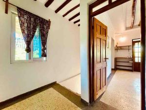 a hallway with a door and a window at Kome-Salsa Garden Comfortable big apartment in Jambiani