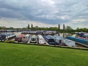 a group of boats parked in a marina on a river at Komet Canal Boats in Nantwich