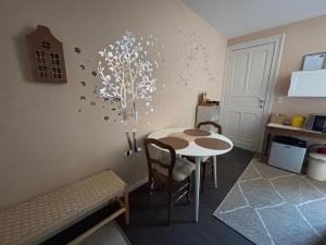 a kitchen with a table and a table and chairs at Au petit nid Froissart in Chimay