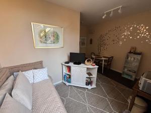 a living room with a couch and a table with a laptop at Au petit nid Froissart in Chimay