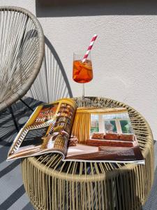a magazine and a drink on a wicker chair at Kertész Vendégház in Siófok