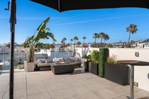 an outdoor patio with furniture and an umbrella at SW Beach Hotel in Hermosa Beach