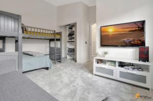 a bedroom with a bunk bed and a television on a wall at Alyeska Slope-Side Sanctuary in Girdwood