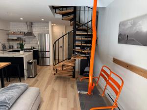 a spiral staircase in a living room next to a kitchen at Alyeska Slope-Side Sanctuary in Girdwood