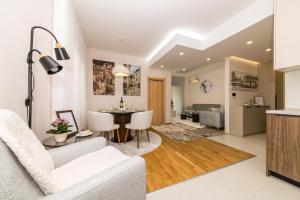 a living room and kitchen with a table and chairs at Luxury Apartment Milos in Dobrota
