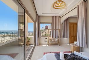 a bedroom with a balcony with a view of the ocean at Surf Appart Morocco in Tamraght Ouzdar