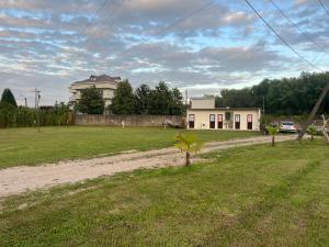 a house in the middle of a grass field at Camping Two Rivers in Shkodër