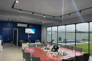 a living room with a table and a tv and a pool at Escobar Sunset in Paraguarí