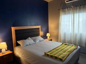 a bedroom with a bed and a blue wall at Escobar Sunset in Paraguarí +25 photos