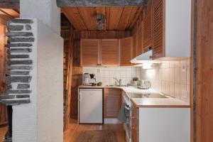 a kitchen with white appliances and wooden cabinets at Kelo Haven, 2 x skipasses Ruka-Pyhä included, skibus nearby in Ruka +19 photos