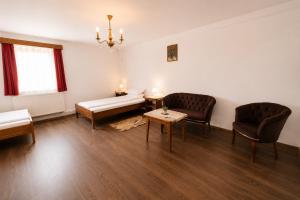 a living room with two chairs and a couch and a table at Pensiunea Alpin Marisel Self Check-in in Mărişel