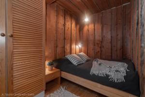 a bedroom with a bed in a wooden wall at Kelo Haven, 2 x skipasses Ruka-Pyhä included, skibus nearby in Ruka