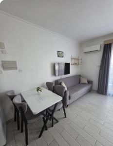a living room with a couch and a table at Kıbrısın gözdesi Long Beach de Havuz manzaralı stüdyo daire in Trikomo