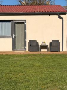 two chairs and a table in front of a house at Sunset holiday house in Liepāja