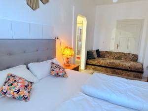 a bedroom with a bed with pillows and a couch at Hotel Dreischläger Hof in Fernthal +43 photos