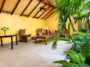 a living room with a wooden table and chairs at Hotel 1915 INN & SUITES in Alajuela +6 photos