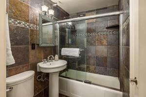 a bathroom with a sink and a toilet and a tub at Downtown Condo Epic Views in Anchorage +18 photos