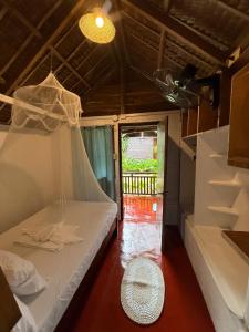 a room with two beds and a window at Zhaya's Beachfront in El Nido