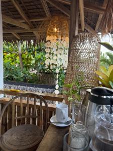a table with a coffee cup and chairs on a patio at Zhaya's Beachfront in El Nido