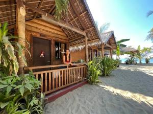 a woman standing in front of a house on the beach at Zhaya's Beachfront in El Nido +32 photos