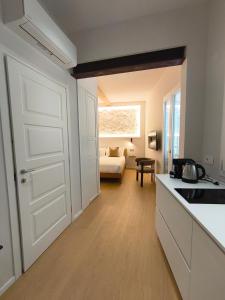 a kitchen with a white door and a living room at Insula Domo in Nuoro