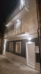 a white building with a balcony on the side of it at Insula Domo in Nuoro